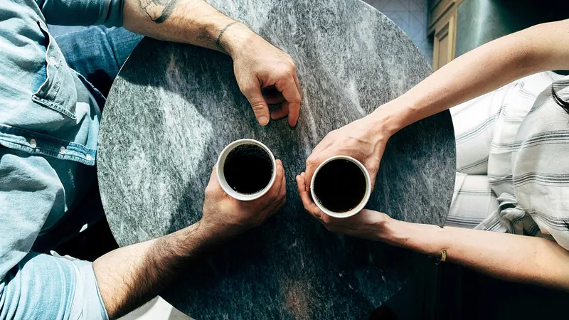 Two people talking over coffee