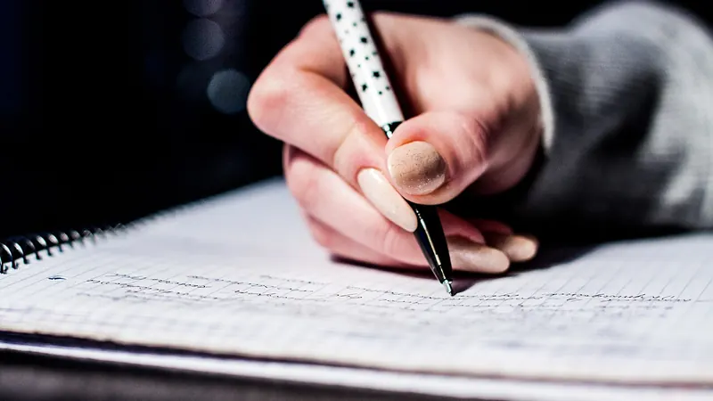 Hand writing notes in a notebook