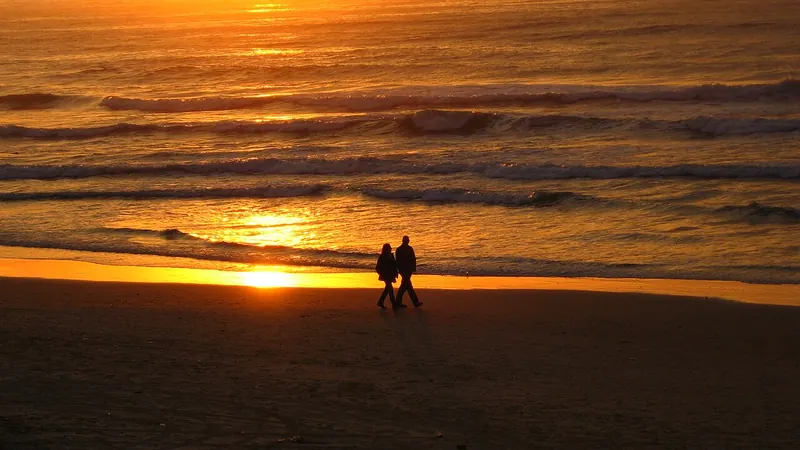 Couple walking on the beach at sunset